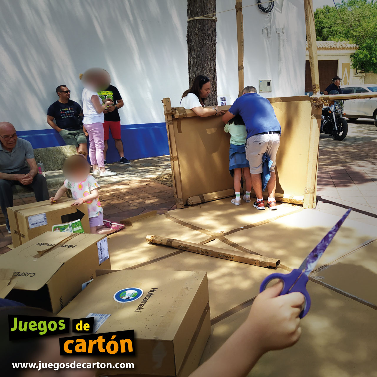 Participantes de todas las edades trabajando juntos en familia para construir una réplica del patrimonio local en cartón. Santa María del Campo Rus (Cuenca, España)