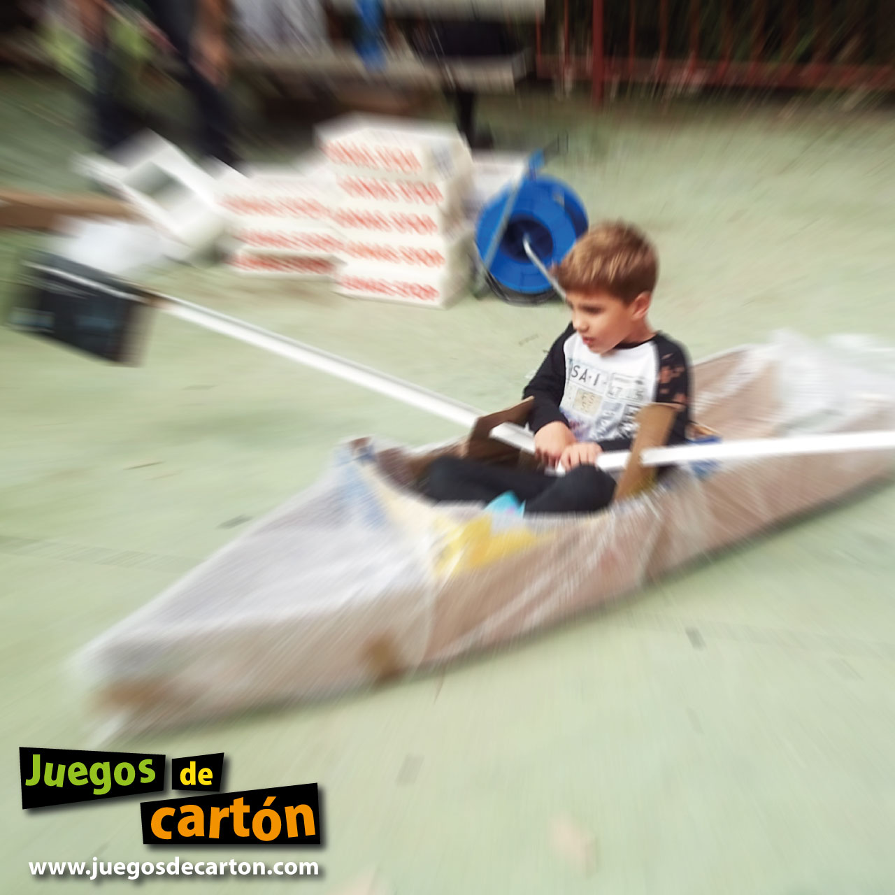 Un niño juega en su piragua hecha de cartón el día del Global Cardboard Challenge. Cuenca (España)